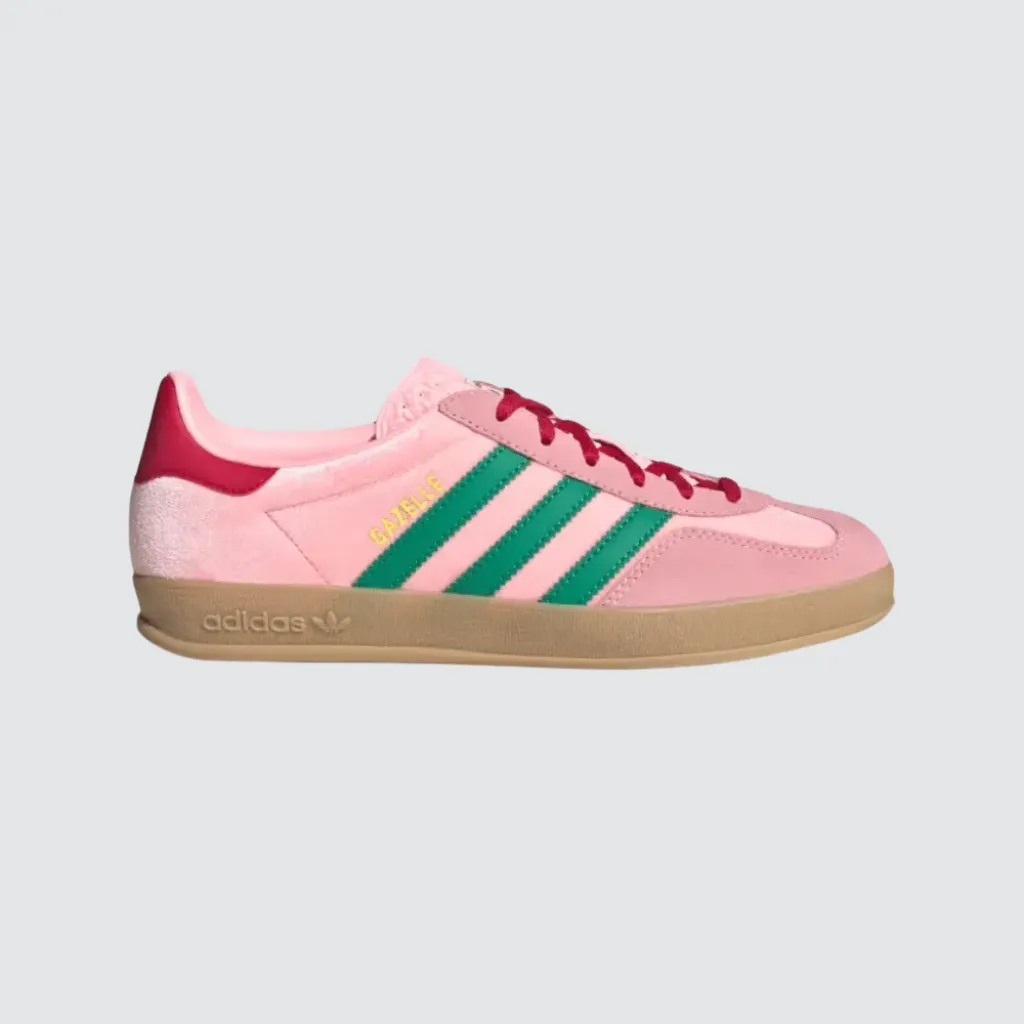 Tênis adidas Gazelle Indoor Glow Pink Court Green com cabedal em veludo rosa, sobreposições em camurça, detalhes em verde, perfil baixo clássico e solado de borracha, representando um sneaker retrô versátil para o lifestyle urbano.