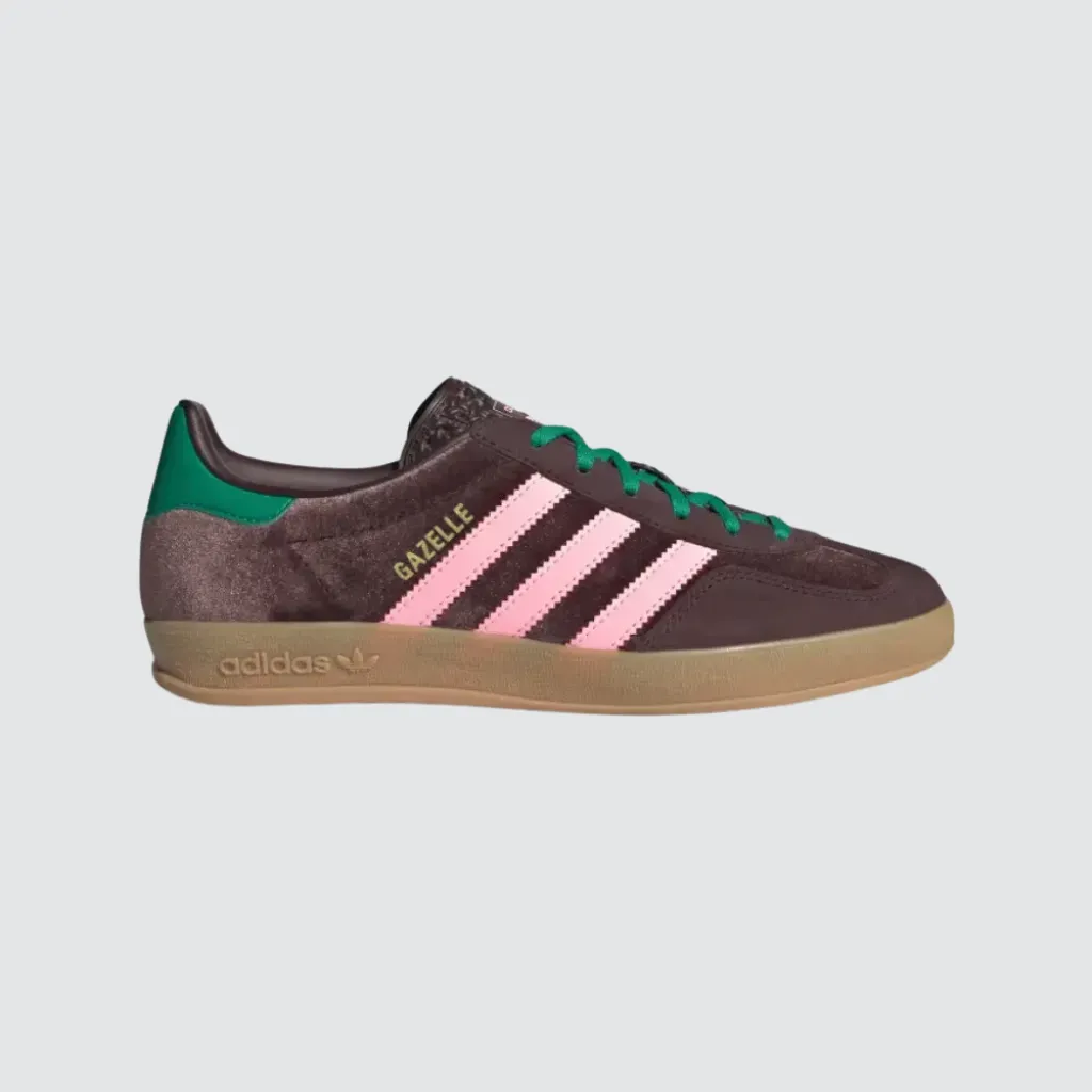 Tênis adidas Gazelle Indoor Dark Brown Glow Pink Court Green com cabedal em veludo marrom, sobreposições em camurça, detalhes em rosa e verde, perfil baixo clássico e solado de borracha, representando um sneaker retrô versátil para o lifestyle urbano.