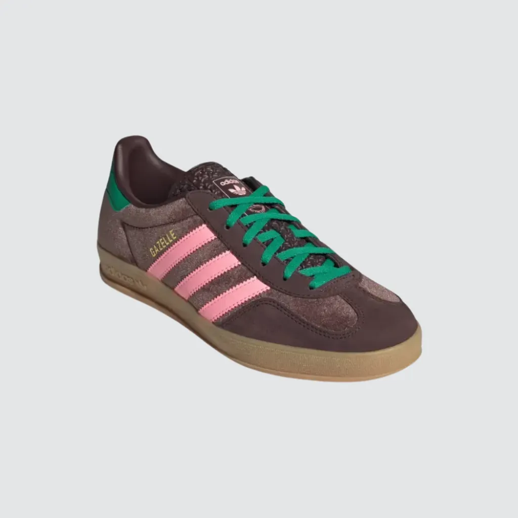 Tênis adidas Gazelle Indoor Dark Brown Glow Pink Court Green com cabedal em veludo marrom, sobreposições em camurça, detalhes em rosa e verde, perfil baixo clássico e solado de borracha, representando um sneaker retrô versátil para o lifestyle urbano.