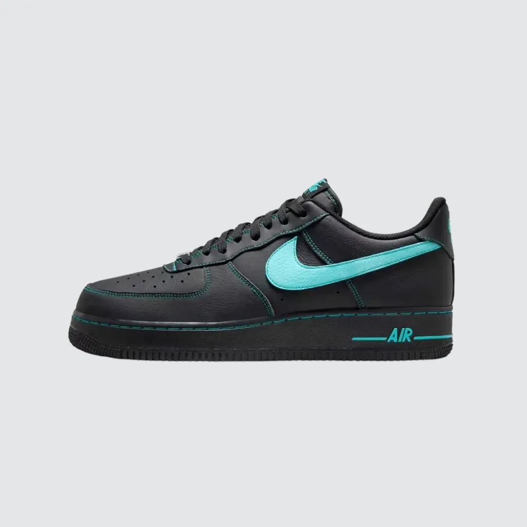 Tênis Nike Air Force 1 Low Black Un‑Tiffany com cabedal preto, Swoosh em tom turquesa Aurora Green, costuras contrastantes, entressola clássica e solado de borracha, representando um sneaker urbano com forte identidade visual.