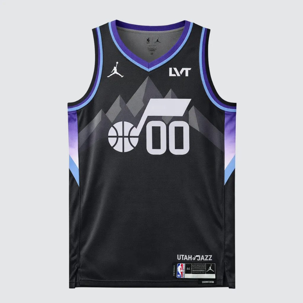 Imagem da Regata Utah Jazz Statement Edition 2025/26 Swingman Nike em preto, com logotipo Jazz Note centralizado no peito, gráfico de montanhas ao fundo, detalhes em roxo e azul claro na gola e nos painéis laterais, tecido mesh respirável, caimento regular e acabamento NBA.