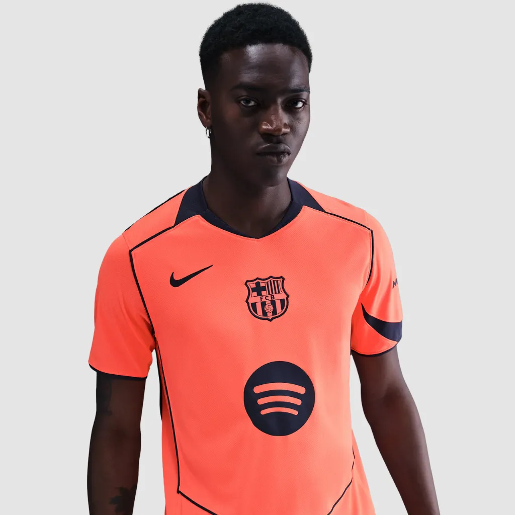 Camisa terceira do Barcelona Nike 2025 2026 laranja com detalhes azul-marinho, escudo centralizado e design inspirado na era Total 90