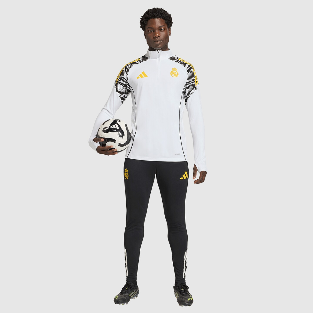 Modelo vestindo o conjunto de treino Real Madrid x Marvel 2026 em ação, destacando mobilidade.