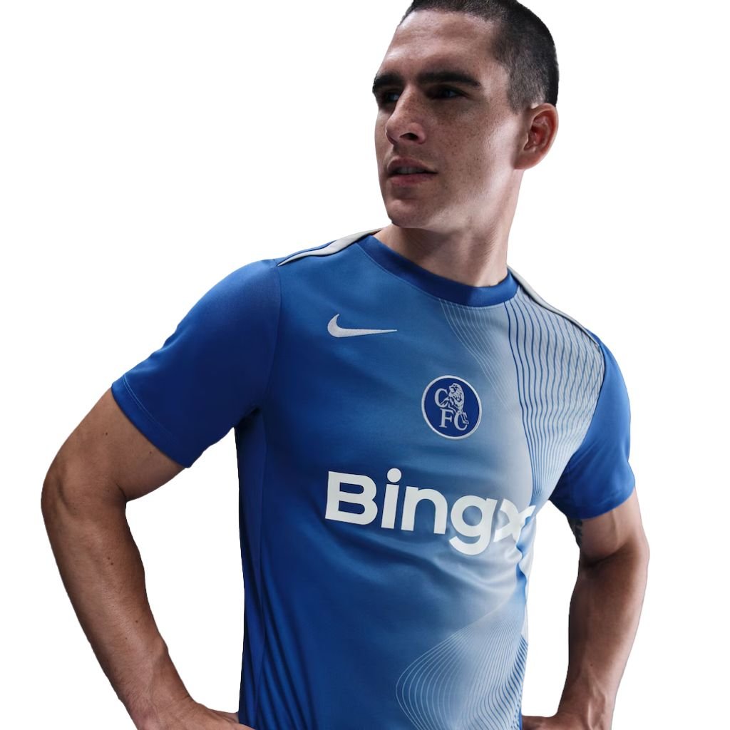 Camisa pré-jogo do Chelsea 2025 Nike azul e branca com design Total 90 e detalhes em degradê azul royal.