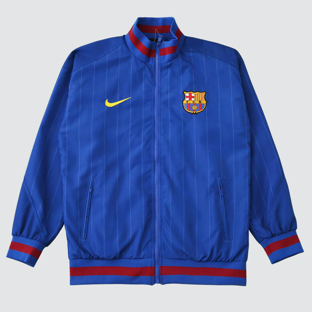 Frente da jaqueta Barcelona Anthem 2025/26 esticada, mostrando o Swoosh amarelo e design clássico.