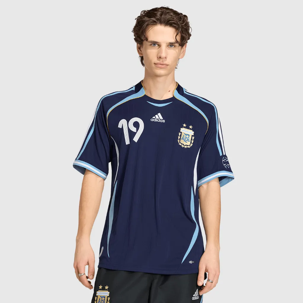 Modelo de frente usando a camisa retrô reserva da Argentina 2006 Messi 19, com visual completo em uso.
