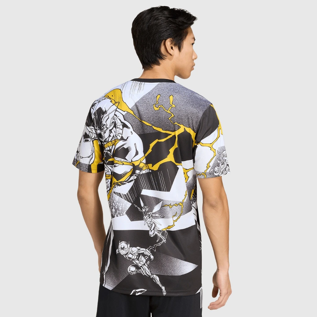 Modelo vestindo a camisa pré-jogo Real Madrid x Marvel 2025 em ambiente casual.