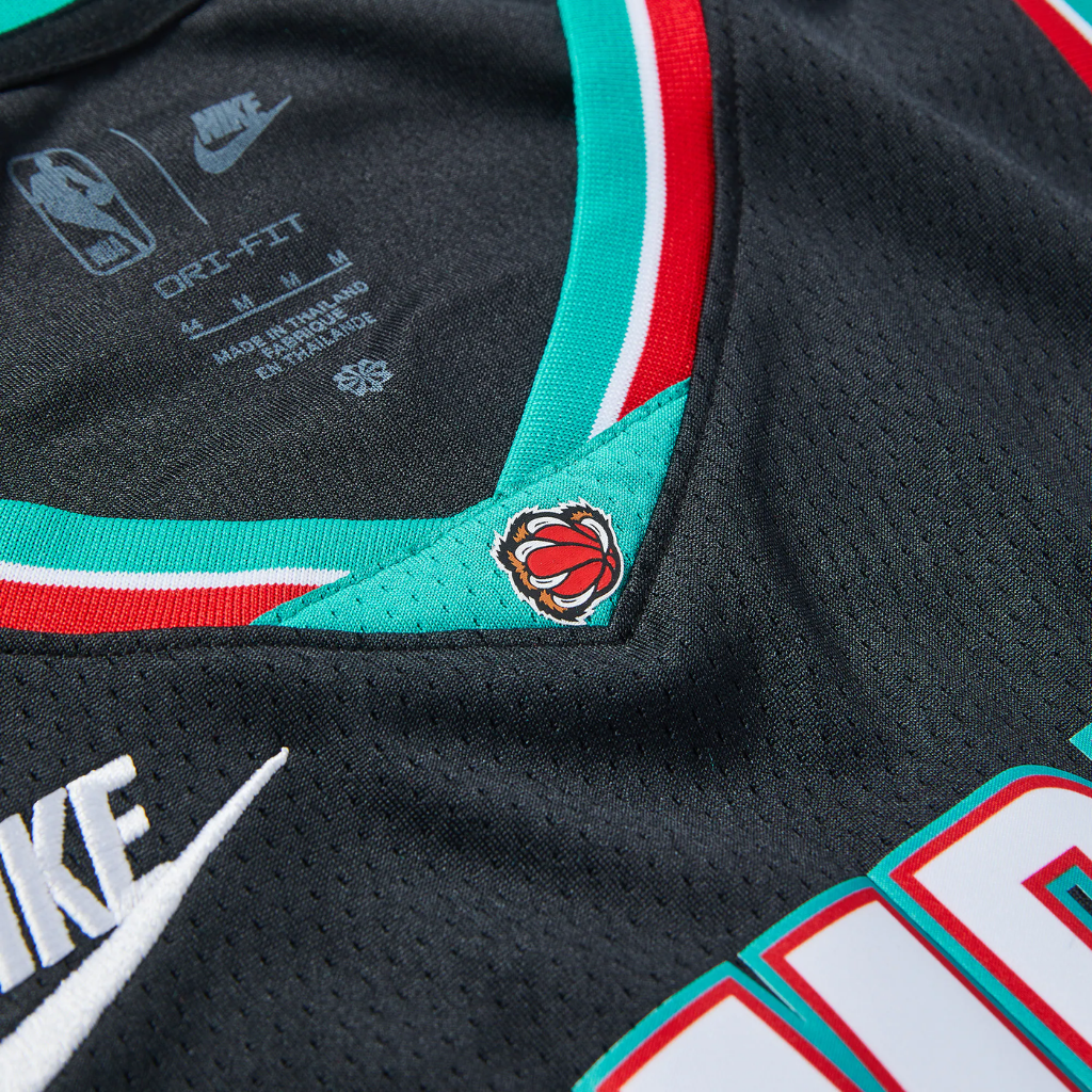 Detalhe da gola e das laterais com faixas vermelha, turquesa e branca no uniforme Classic Edition