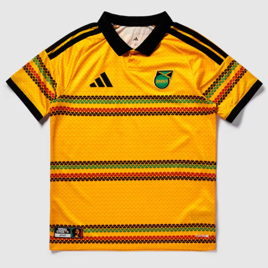 Camisa titular da Jamaica adidas 2026 amarelo-dourada com listras horizontais vermelhas e pretas, design inspirado na cultura rastafári e identidade caribenha